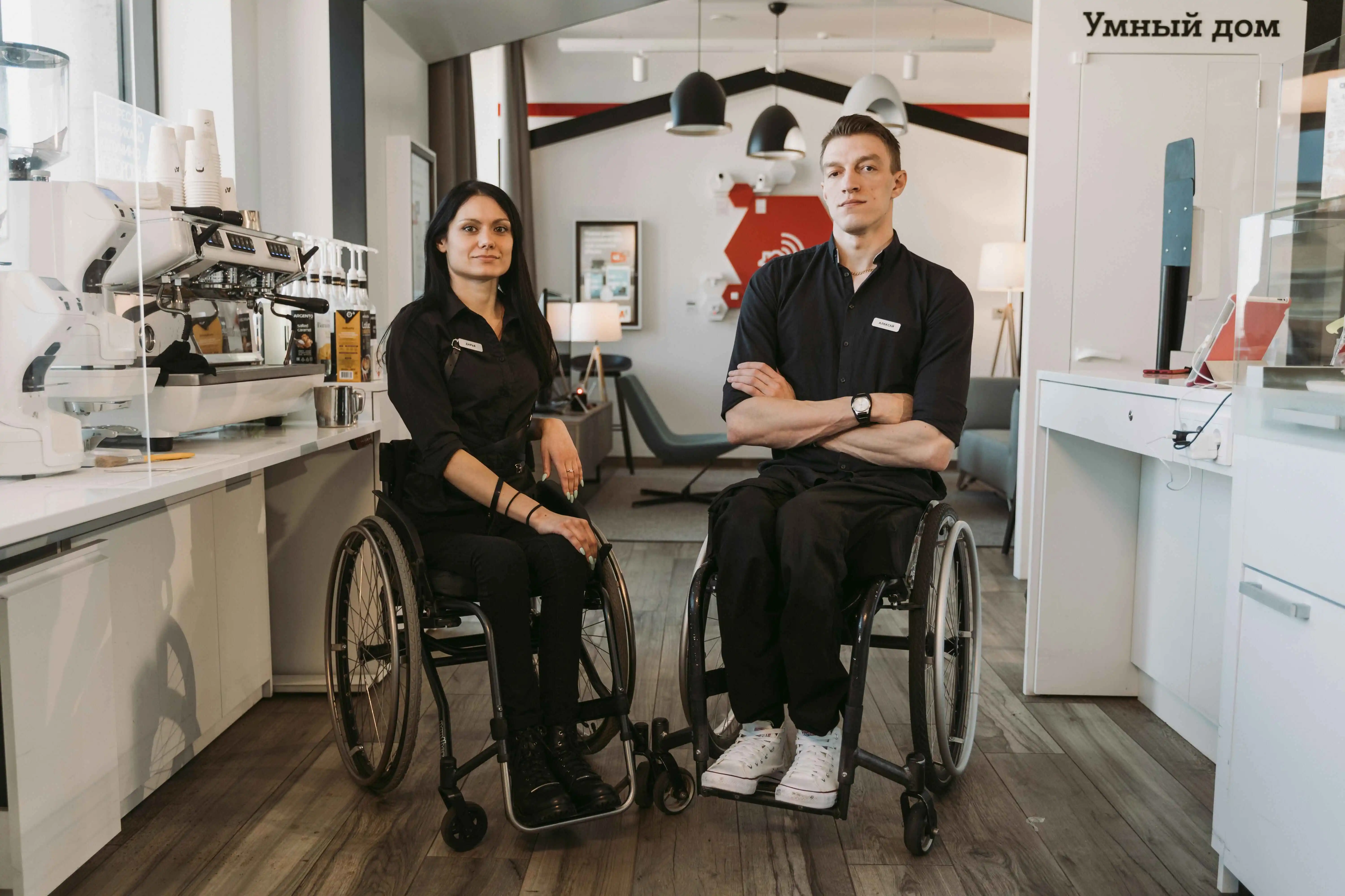Two baristas in wheelchairs.