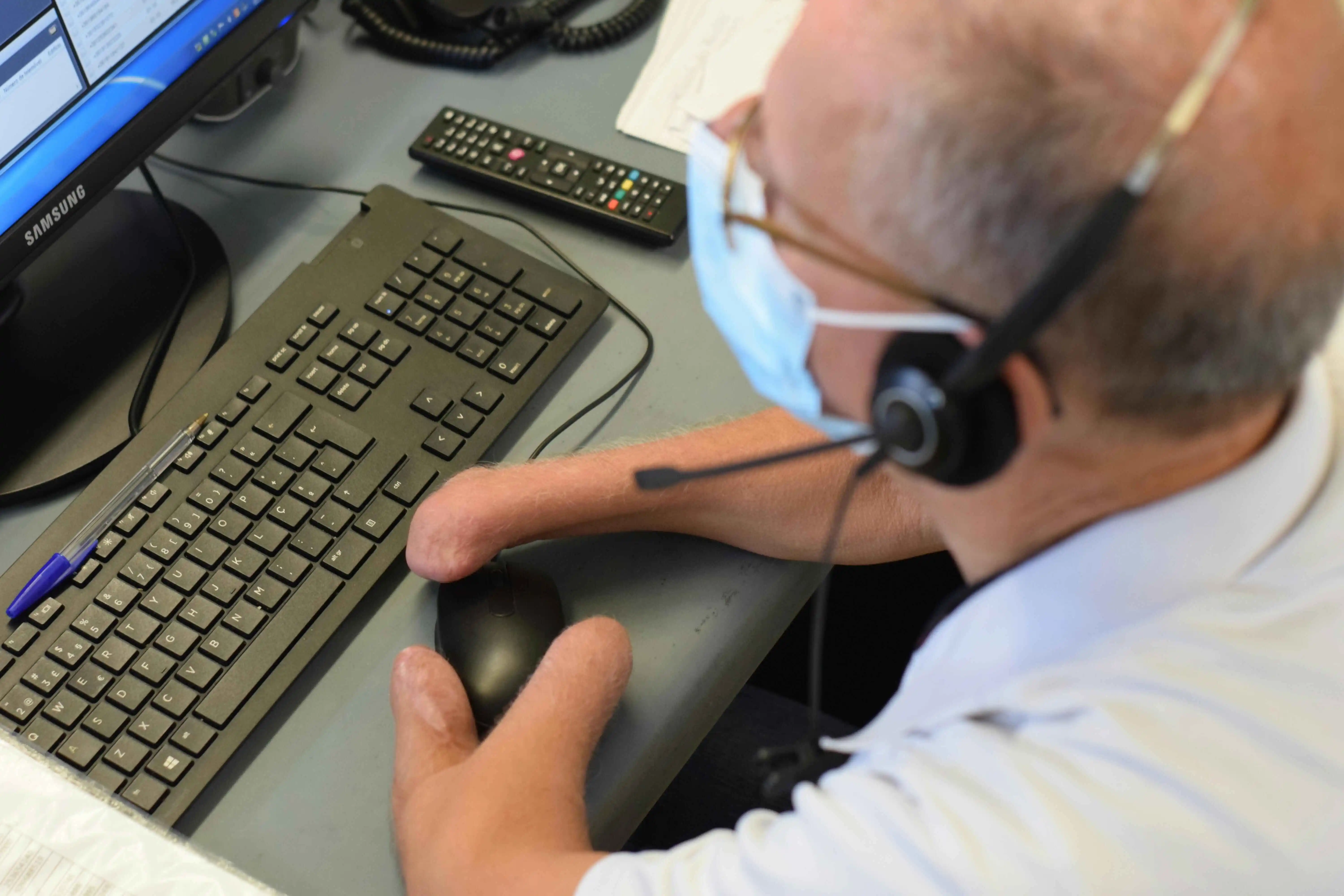 A physically disabled worker uses a keyboard and mouse.